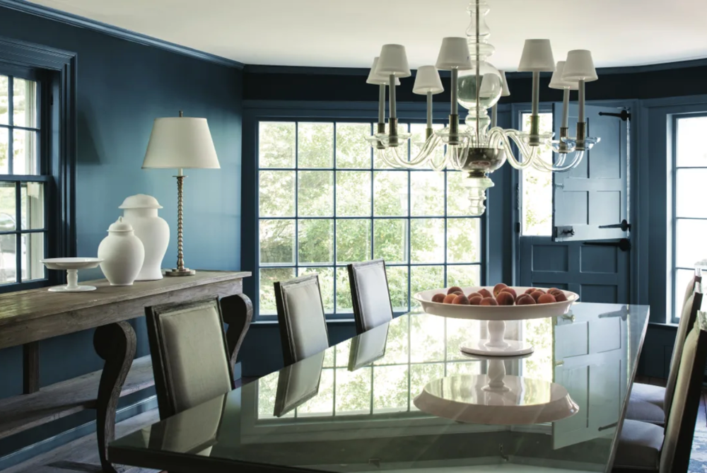 dining room with blue painted walls, a chandelier, and a long dining table with chairs