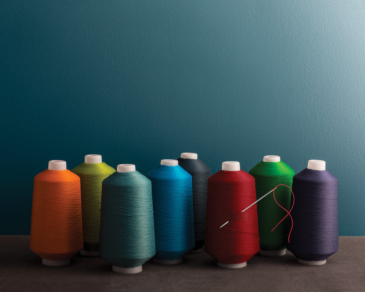 Multicolored sewing spools reflect the accentuated response to light found in Aura® Color Stories®.