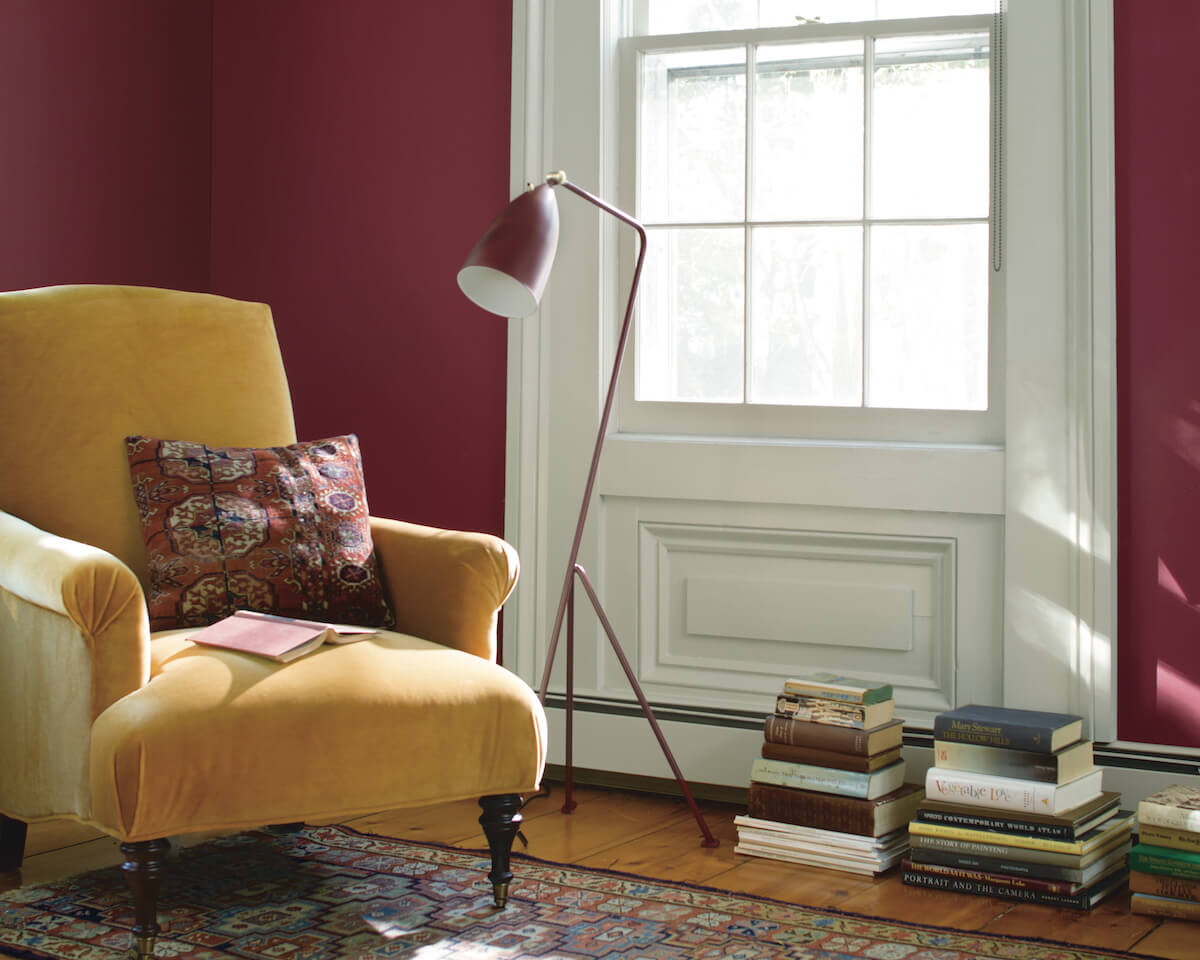 Magenta wall with yellow velvet chair